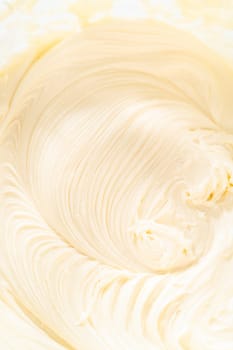 Skillfully combine ingredients using a hand mixer to prepare a rich, smooth cream cheese buttercream frosting, which is perfect for adorning the bundt cake.