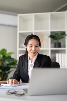 Young business woman asian or employee accounting bookkeeping documents checking financial data or marketing report working in office with laptop. Paperwork management.