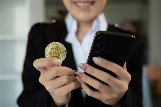 A successful business woman holds the cryptocurrency Bitcoin in her hands. Concept of trading and using digital currencies.