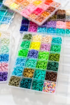 Assorted clay bead boxes neatly arranged on a white table, awaiting a creative kids' craft project.