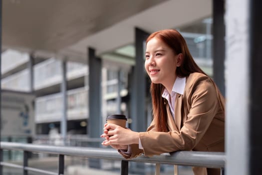 Beautiful successful business woman in walking on the street in business town with coffee. Preparation for the working day.