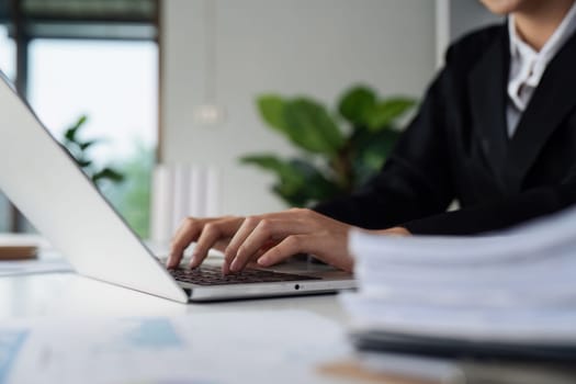 Businesswoman analyzing marketing strategy on laptop, typing work on laptop.