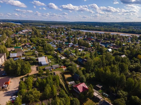 Drone view of bridge above river between lush trees and dwelling buildings in region of Kirov Russia