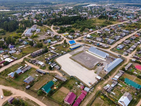 Amazing drone view of small town with residential houses located among green trees