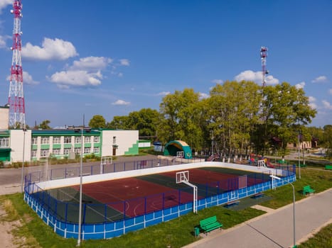 Sports ground between pavement and radio masts under cloudy blue sky in region of Kirov Russian Federation