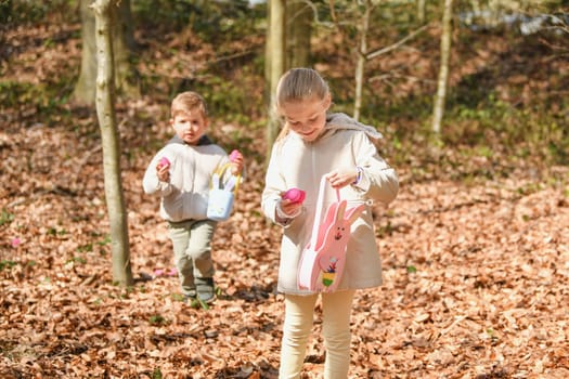 Children collects the eggs in a basket Easter