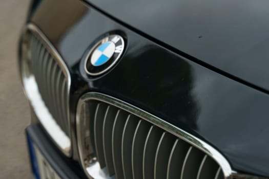 Warsaw, Poland - August 6, 2023: BMW logo on the hood of a black car. Selective sharpening.
