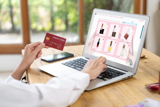 Woman shopping online on internet marketplace browsing for sale items for modern lifestyle and use credit card for online payment from wallet protected by uttermost cyber security software