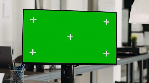 Greenscreen computer display on desktop, empty small business office. Isolated mockup template shown on modern monitor screen, blank copyspace with chromakey technology, digital software.