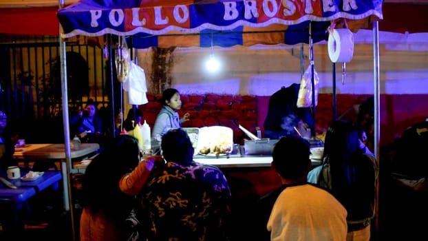 Lima, Peru - September 7, 2019 : A bustling night street food stand offering local cuisine with customers waiting, city of Canta located north of Lima - Peru