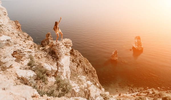 Woman travel sea. Happy tourist taking picture outdoors for memories. Woman traveler looks at the edge of the cliff on the sea bay of mountains, sharing travel adventure journey.