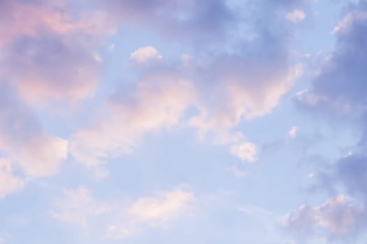 Background of blue sky with pale pink clouds at sunset