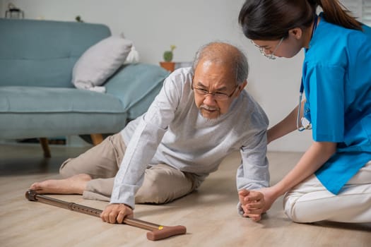 Asian older senior man falling down on lying floor and woman nurse came to help support, Disabled elderly old man patient fall down and caring young assistant at nursing home