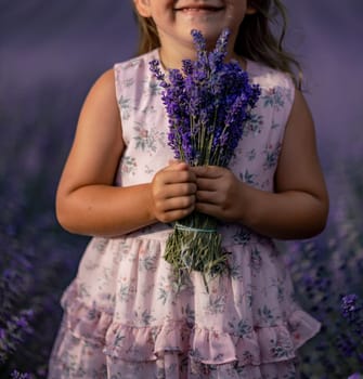 girl lavender field in a pink dress holds a bouquet of lavender on a lilac field. Aromatherapy concept, lavender oil, photo shoot in lavender.