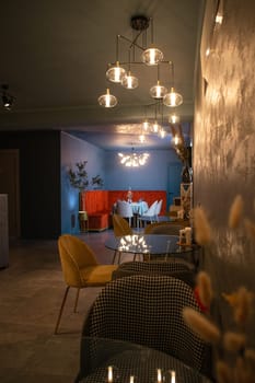 Elegant restaurant with dim lighting, stylish furniture, dark walls, tables, chairs, bar, and kitchen for romantic dinners.