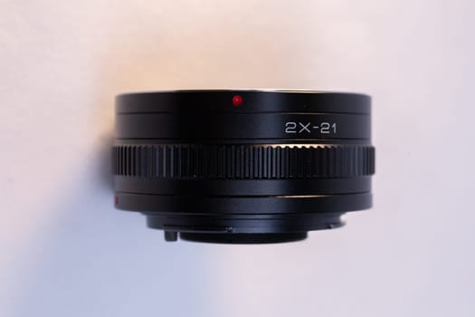 A black camera telephoto lens converter on a white background, perfect for photography enthusiasts and professionals.