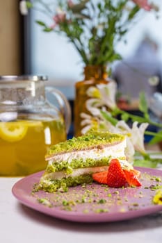 Indulge in a delightful treat with this scrumptious green cake, adorned with fresh strawberries, and elegantly presented on a pink plate.