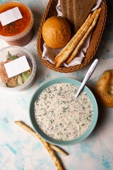 top view a plate of okroshka and fresh bread on the table.