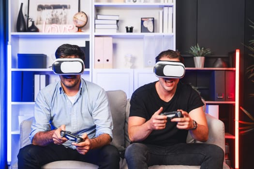 Buddy friend gamers playing video game using joysticks and VR headset of virtual technology in reality in studio room with neon blue light. Comfy living indoor with cheerful fighting winner. Sellable.