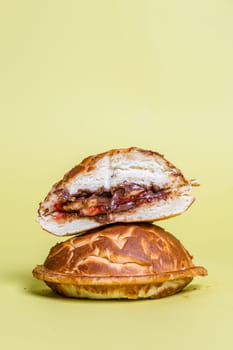juicy burger cut with delicious filling on a yellow background.