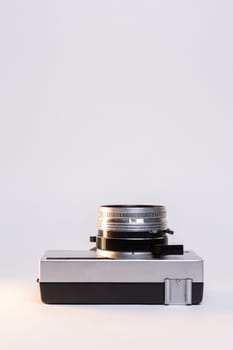 Vintage film camera with a sleek silver body and a classic black manual focus lens, elegantly displayed against a clean white background.