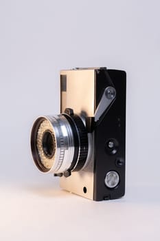 Vintage film camera with a sleek silver body and a classic black manual focus lens, elegantly displayed against a clean white background.