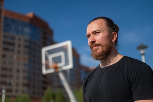 Portrait of a Caucasian bearded man on a basketball court outdoors