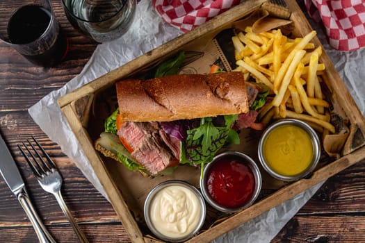 Grilled steak sandwich with french fries on a white porcelain plate