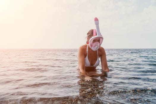 Young happy woman in white bikini put pink snorkeling mask on beach before swimming. girl having fun relaxing on beautiful beach. Beach lifestyle