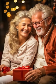Happy aged couple with gifts for Christmas. High quality photo