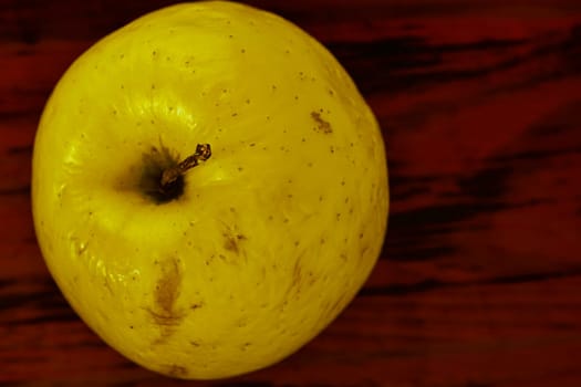 Whole yellow  apple on wooden background ready to eat