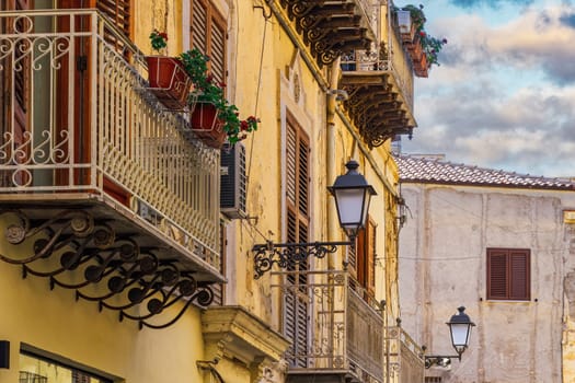 Agrigento traditional architecture houses with iron balconies, lanterns and decayed facade in Sicily, Italy.