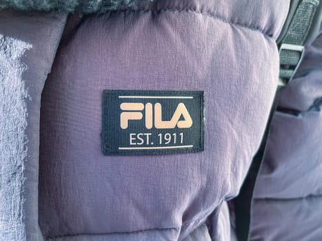 Tyumen, Russia-January 11, 2024: Fila brand logo on a purple fabric, showcasing the prominent FILA EST. 1911