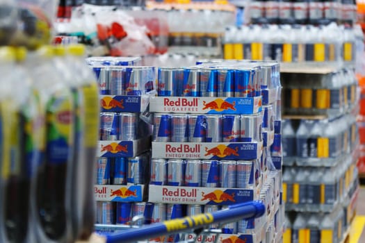 Tyumen, Russia-March 02, 2024: Display in a store is overflowing with cans of Red Bull energy drink, neatly stacked and organized to attract customers.