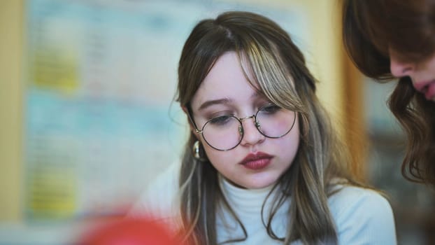 Schoolgirl with glasses at her desk at school