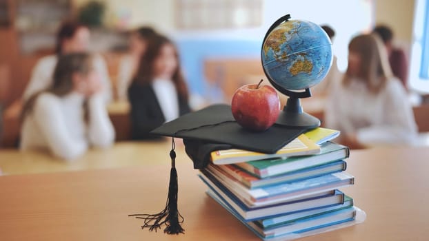 Class with students against background of books, apple, globe and graduation cap