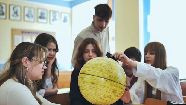 High school students looking at the yellow globe of the moon