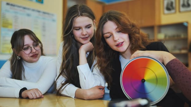 Students in physics class spin Newton's colorful wheel.