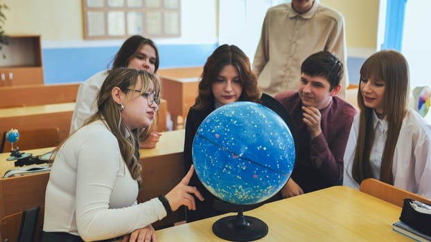 Students look at a globe of the starry sky in a classroom at school