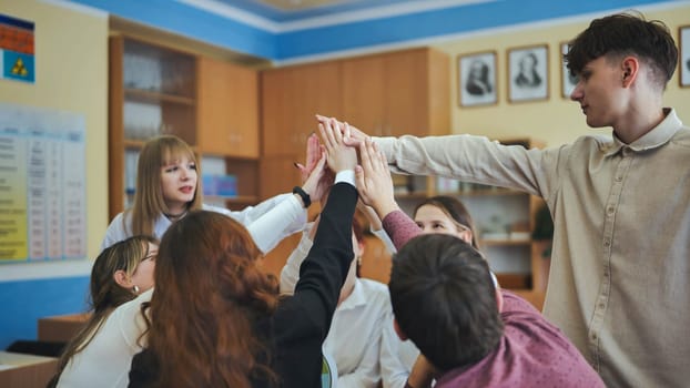 High school seniors join hands in class as a sign of working together