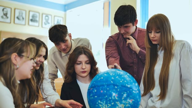 Students look at a globe of the starry sky in a classroom at school