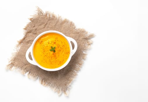 Pumpkin soup with croutons on white background, with copy space for text.