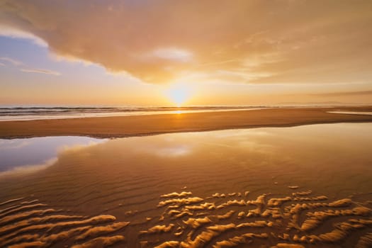 Atlantic ocean sunset with surging waves at Fonte da Telha beach, Costa da Caparica, Portugal