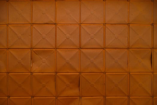 full-frame background and texture of square stamped sheet metal tiles with diagonal ribs.