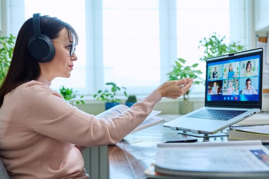 Woman teacher in headphones teaching online, high school students on laptop computer screen, video conference. Remote meeting, consultation, e lesson, training, education, technology concept