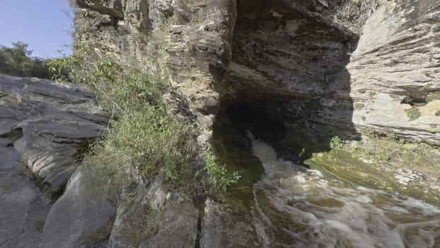 Slow-motion video shows a strong water jet from a dark cave.