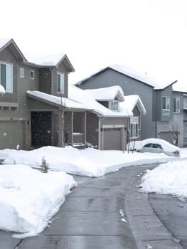 Castle Rock, Colorado, USA-March 16, 2024-Snow blankets a suburban street, where houses stand in quiet repose and driveways reveal the morning labor against the winter relentless drifts.