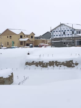 Castle Rock, Colorado, USA-March 16, 2024-Fresh snowfall gently covers a new suburban neighborhood under construction, where the emerging structures await completion, nestled in a wintery setting.