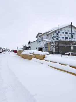 Castle Rock, Colorado, USA-March 16, 2024-Fresh snowfall gently covers a new suburban neighborhood under construction, where the emerging structures await completion, nestled in a wintery setting.