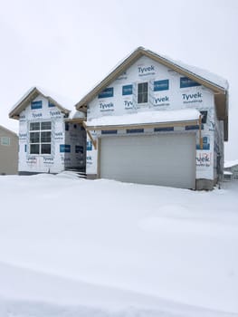 Castle Rock, Colorado, USA-March 16, 2024-Fresh snowfall gently covers a new suburban neighborhood under construction, where the emerging structures await completion, nestled in a wintery setting.